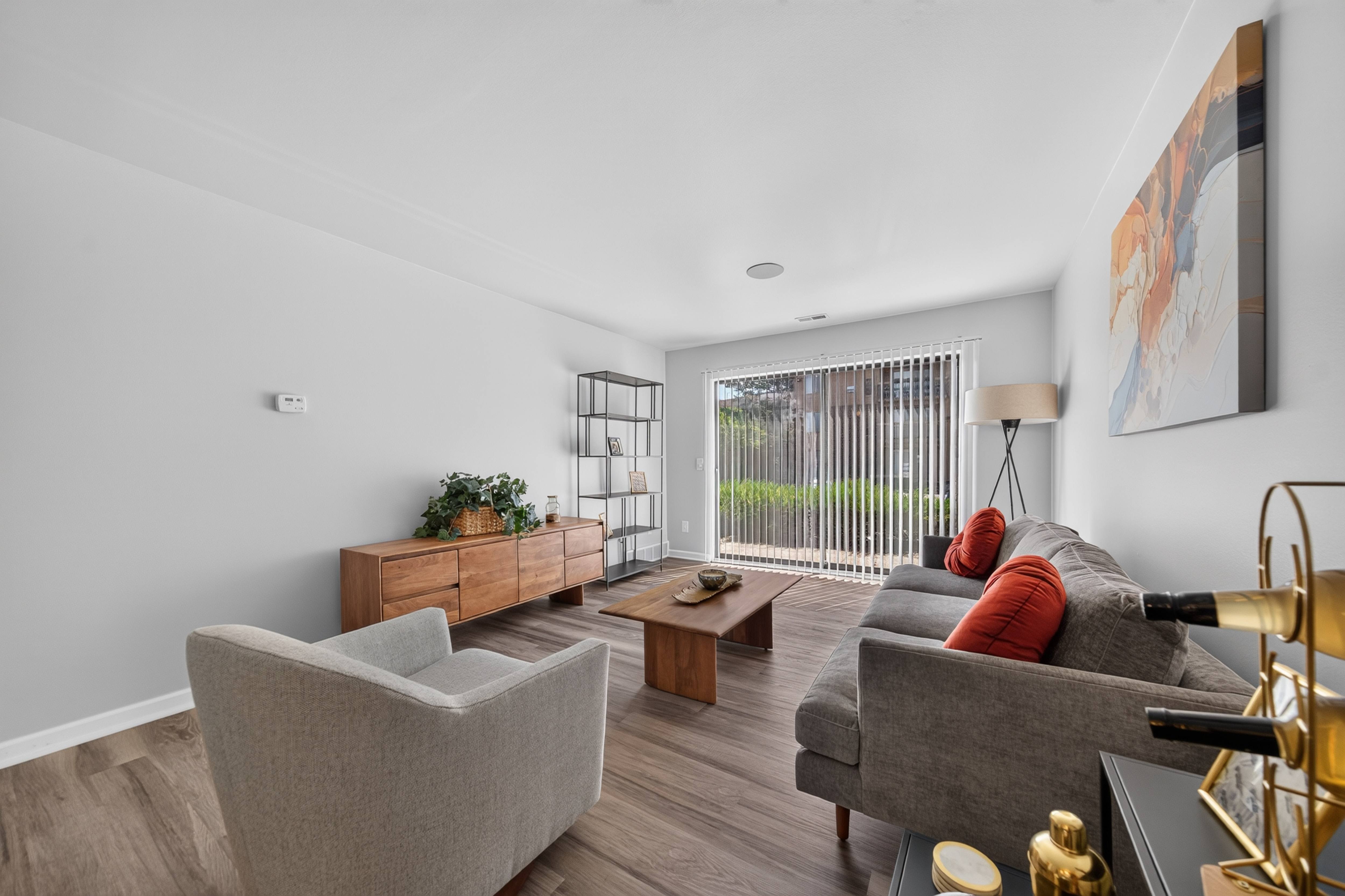 Spacious Living Room with Sliding Glass Door at Lakeside Village Apartments in Clinton Township, MI