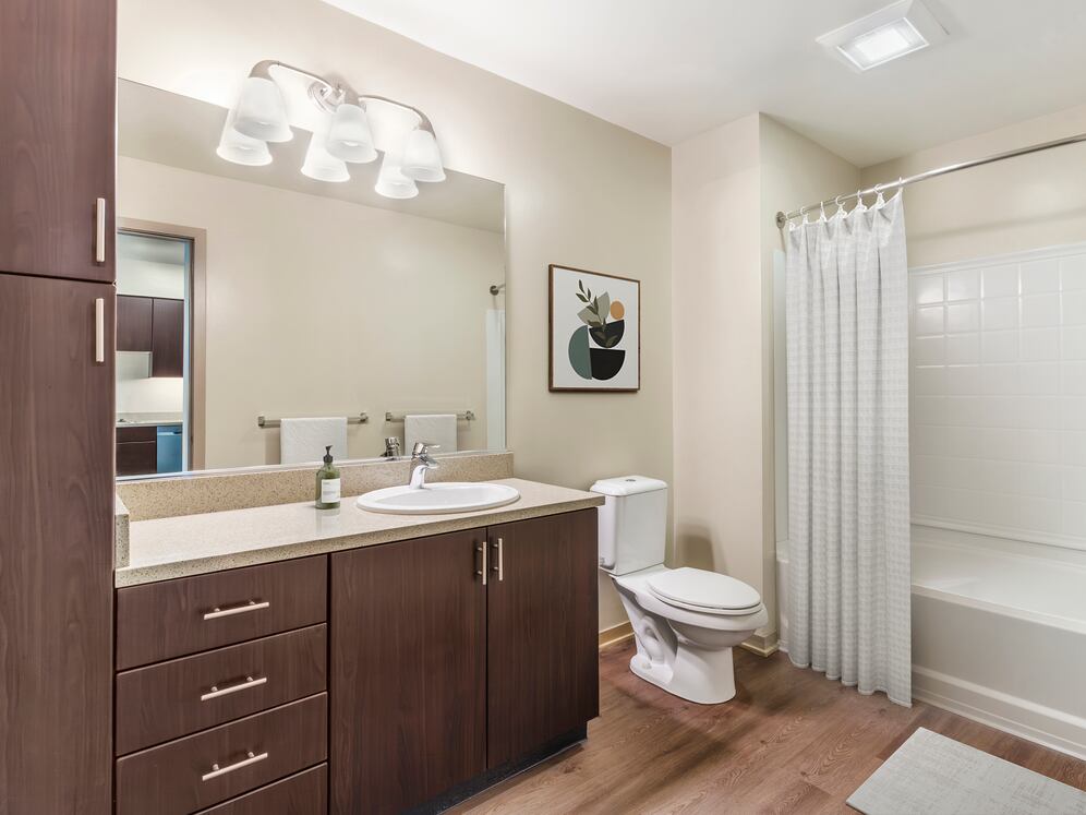 Renovated Package I bath with grey speckled granite countertop, espresso cabinetry, and hard surface flooring