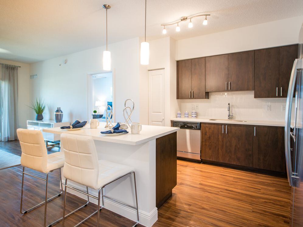 Kitchen with oak cabinetry, white countertops, white tile backsplash, and stainless steel appliances