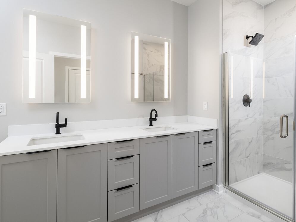 Signature Collection Primary bath with dual vanity sinks, grey shaker cabinetry, white quartz countertop, and LED vanity mirrors