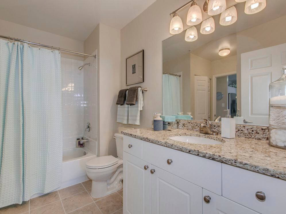 Bathroom with white cabinetry, granite countertop and tile flooring