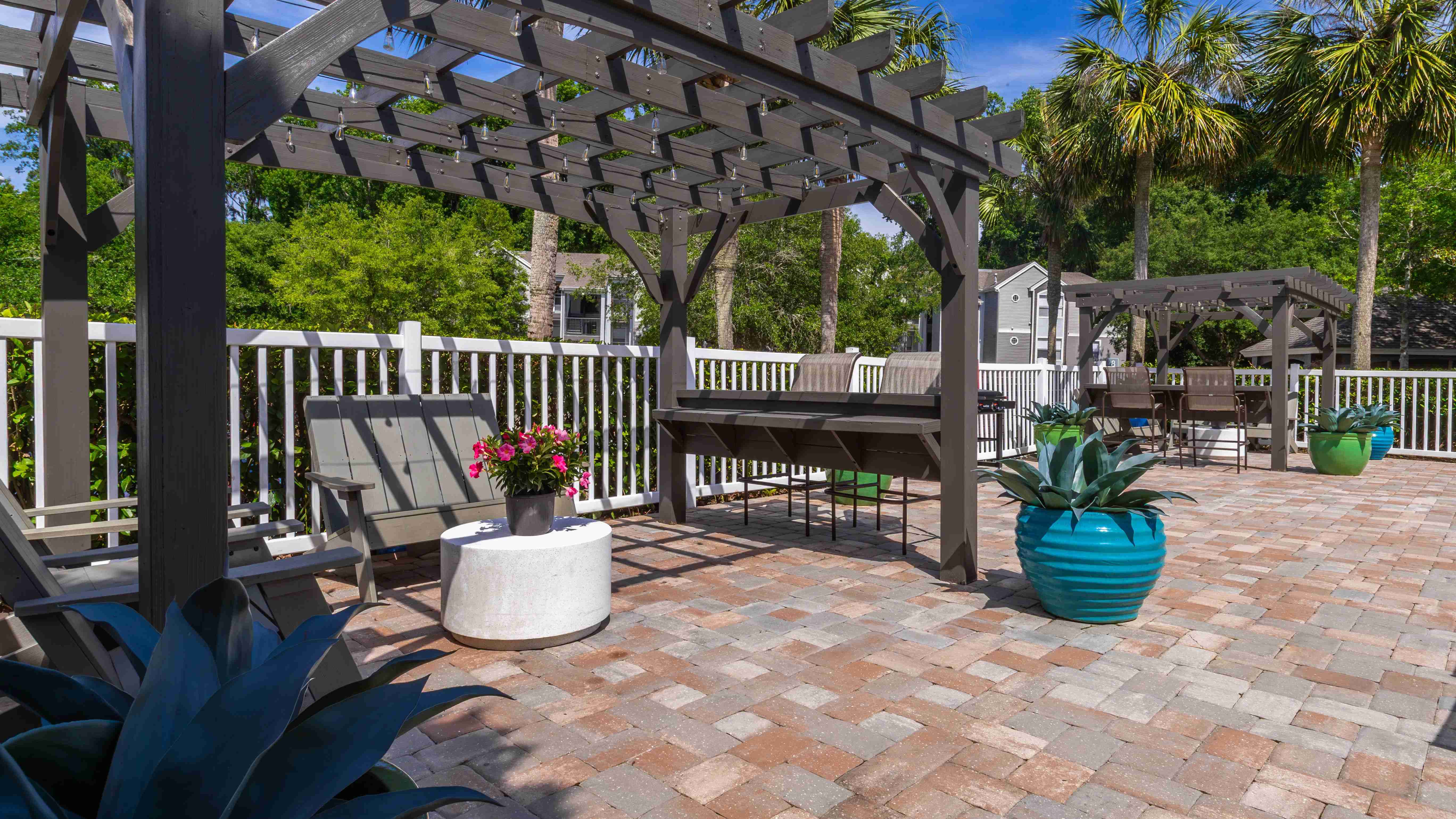 Unwind beneath the pergolas at The Enclave, offering a cozy, shaded spot for relaxing poolside in comfort.