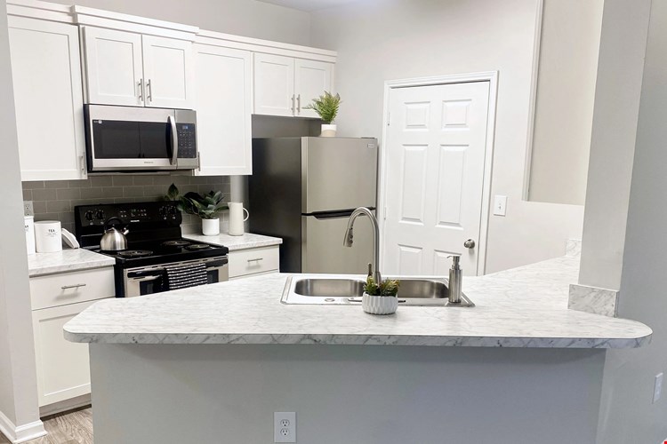 Carrara-marble inspired countertops add a touch of flair and style to select apartment kitchens.