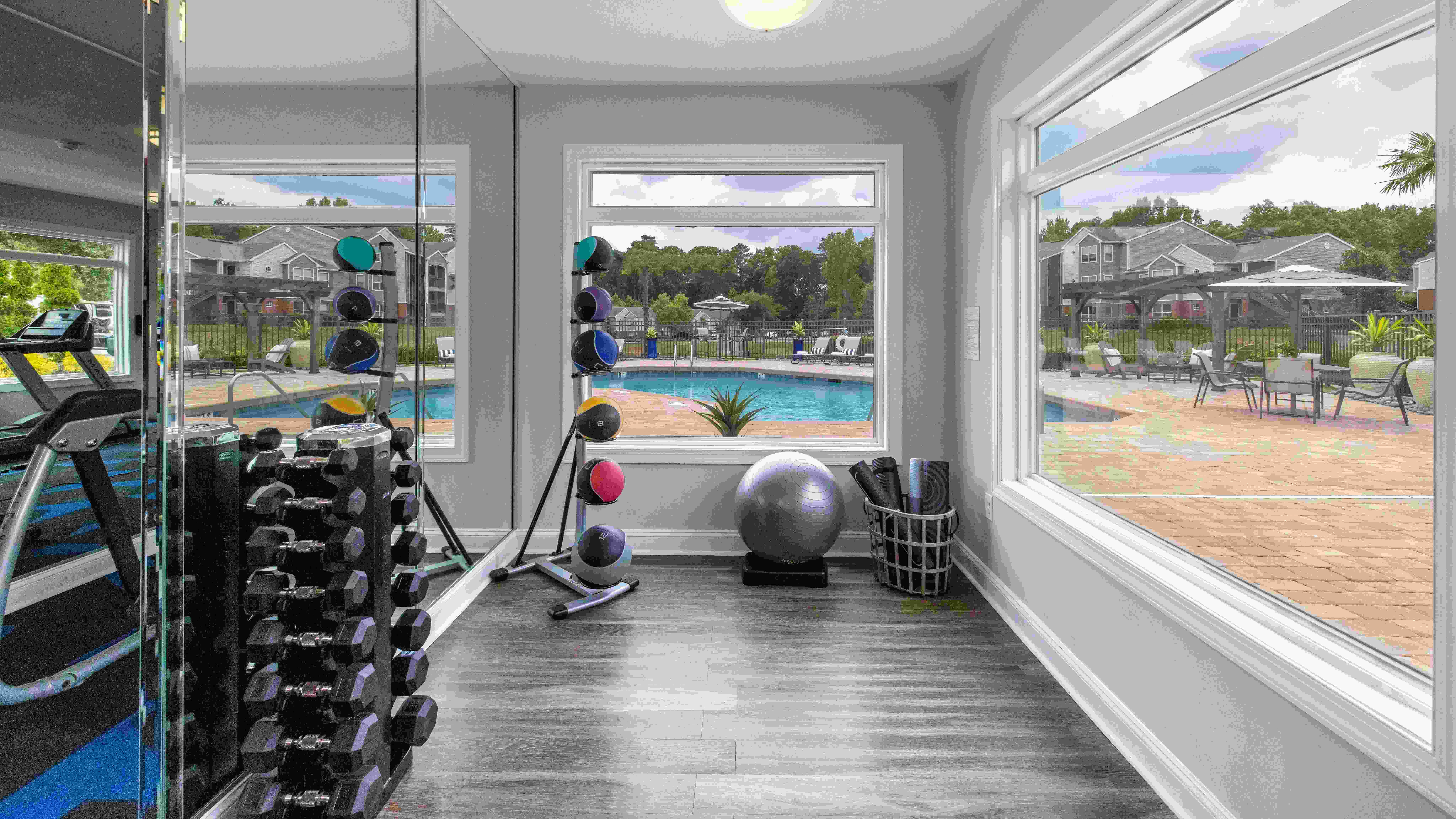 Dedicated space with panoramic pool-deck views for yoga, stretching, and free weights. 
