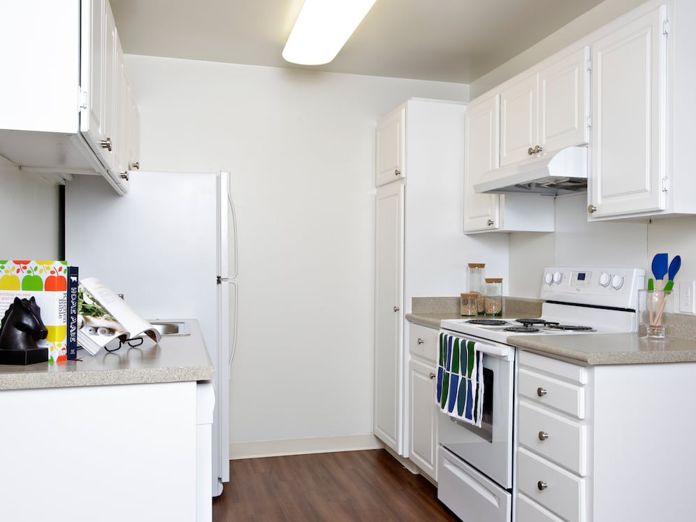 Classic Package I kitchen with white appliances, white cabinetry, beige laminate countertops, and hard surface flooring