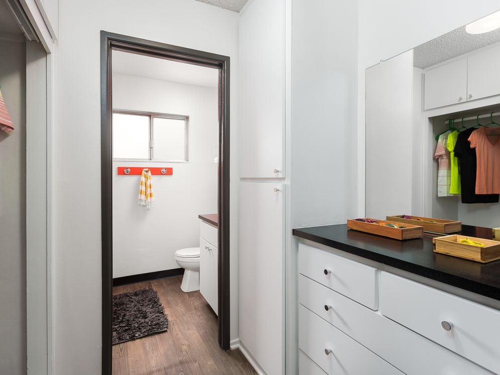 Classic Package II bath with black laminate countertops, white cabinetry, and hard surface flooring