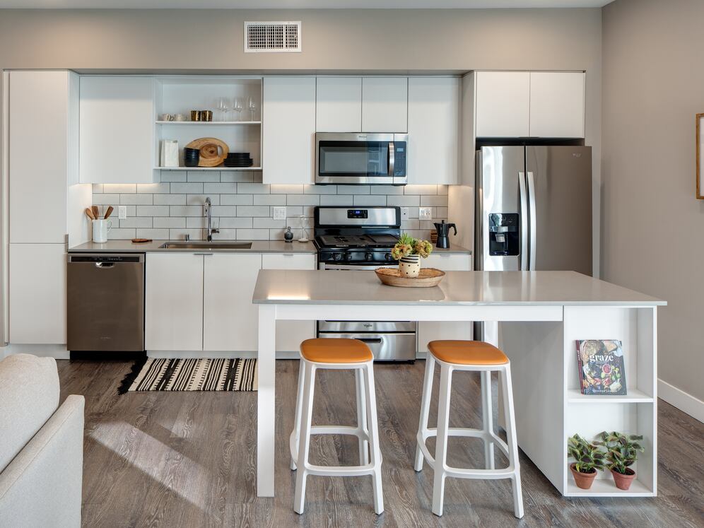 Open concept kitchen with quartz countertops, island, tile backsplash, and stainless steel appliances