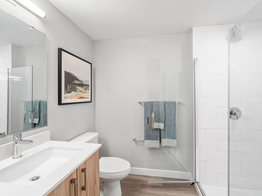 Finish Package II Bath with oak cabinetry, white quartz countertops, and hard-surface vinyl plank flooring