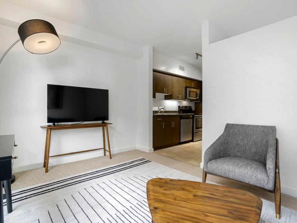 Furnished+ apartment homes come outfitted with a sofa, side chair, side table, coffee table, TV stand and 50" Television (Representative Image – exact items and style of furnishings may vary)