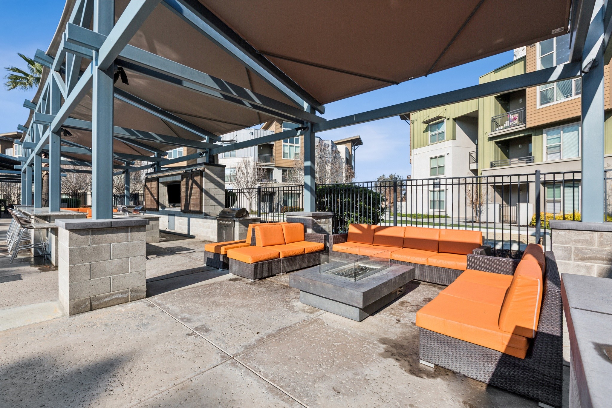Aspire Apartments Tracy California Luxury Living A patio with black wicker furniture and orange cushions.