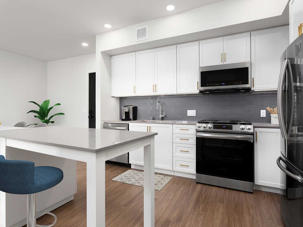 Building A Upgrade Design 2 kitchen with quartz countertops, stainless steel appliances, backsplash and island