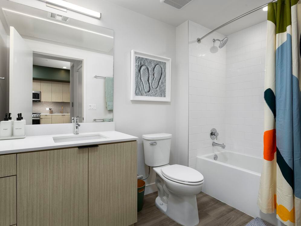 Finish Package I Bath with light oak cabinetry, white quartz countertop, and hard-surface flooring