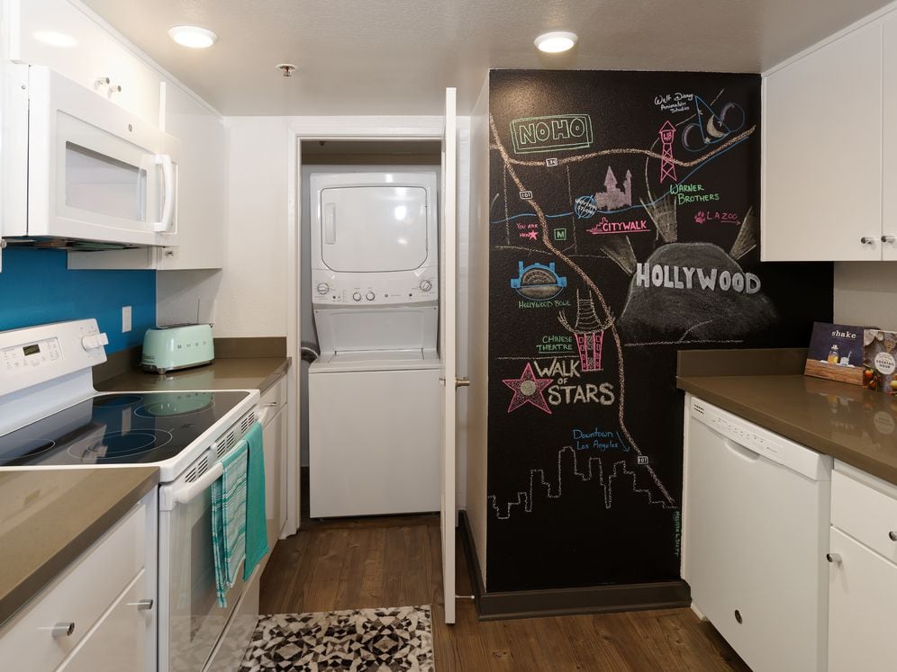 Standard Apartment Kitchen with Chalkboard Accent Wall and Washer Dryer