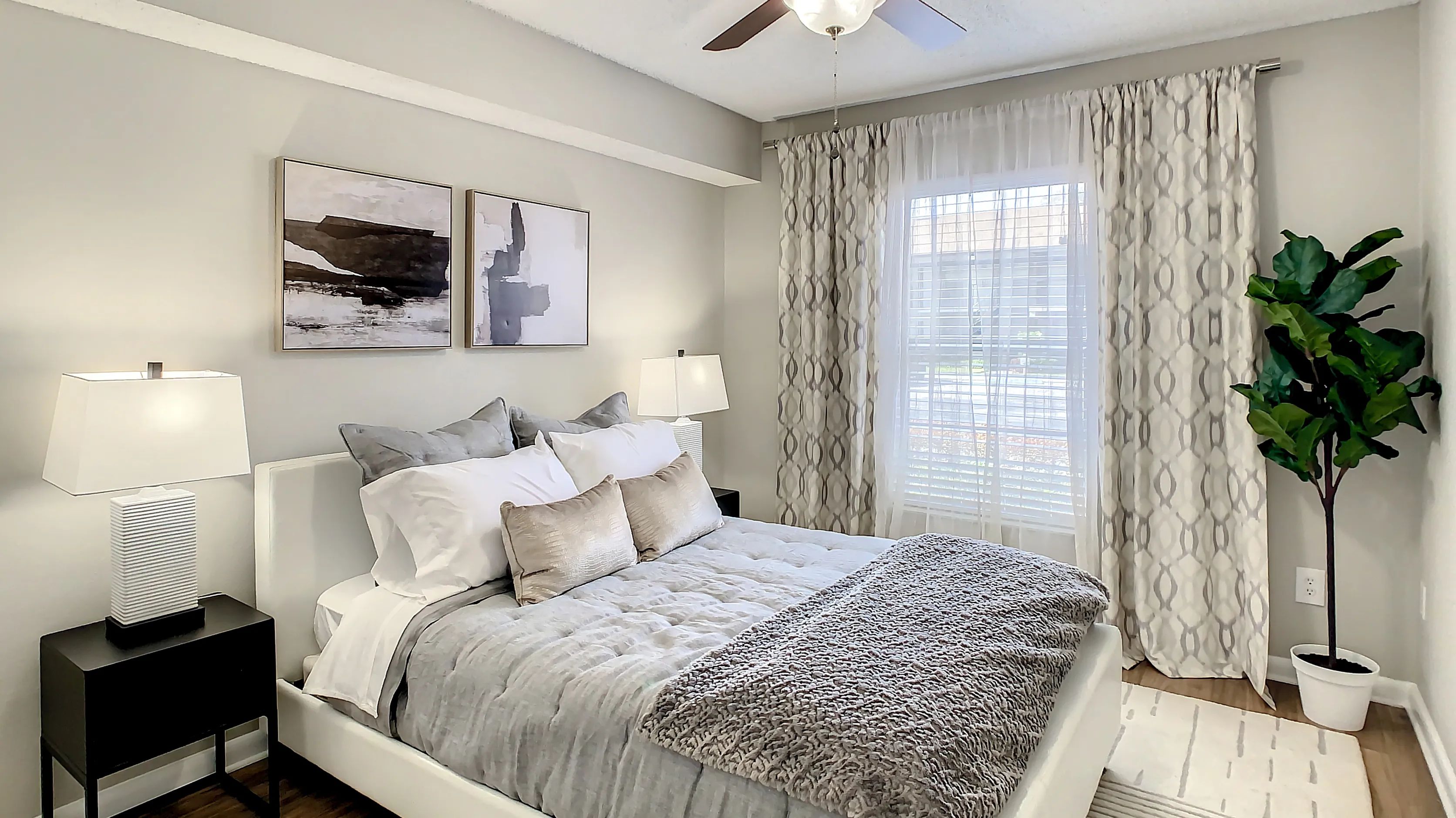 Discover serenity in our spacious bedroom with ceiling fan comfort and expansive sunlit windows.