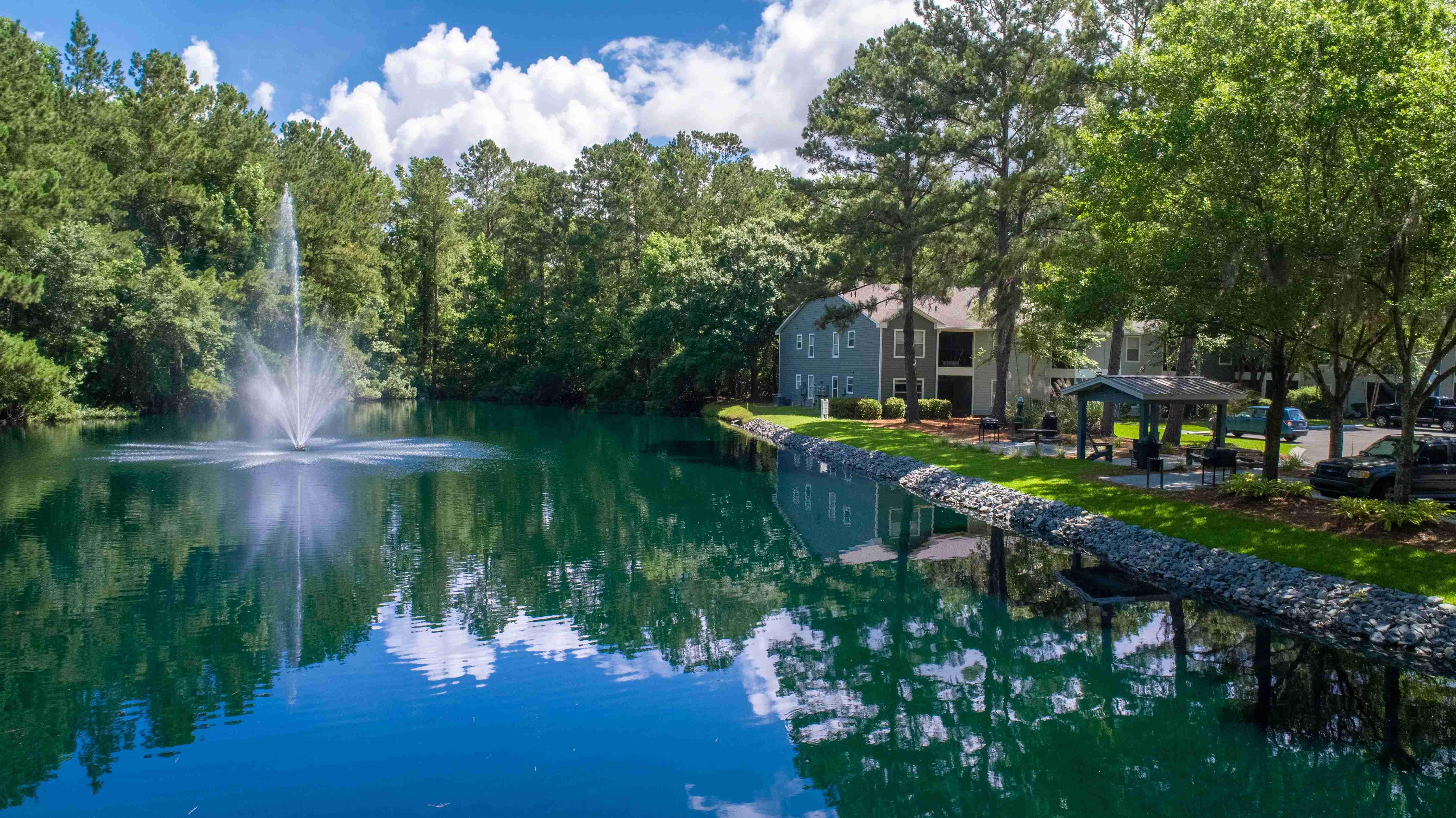 Serene waters, a central fountain, and lush green surroundings create a peaceful oasis right in the heart of the community.