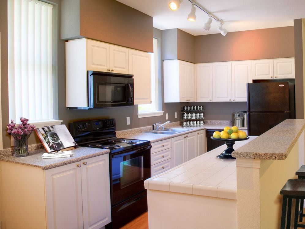 Classic Package II kitchen with black appliances, laminate countertops, white cabinetry, and hard surface flooring