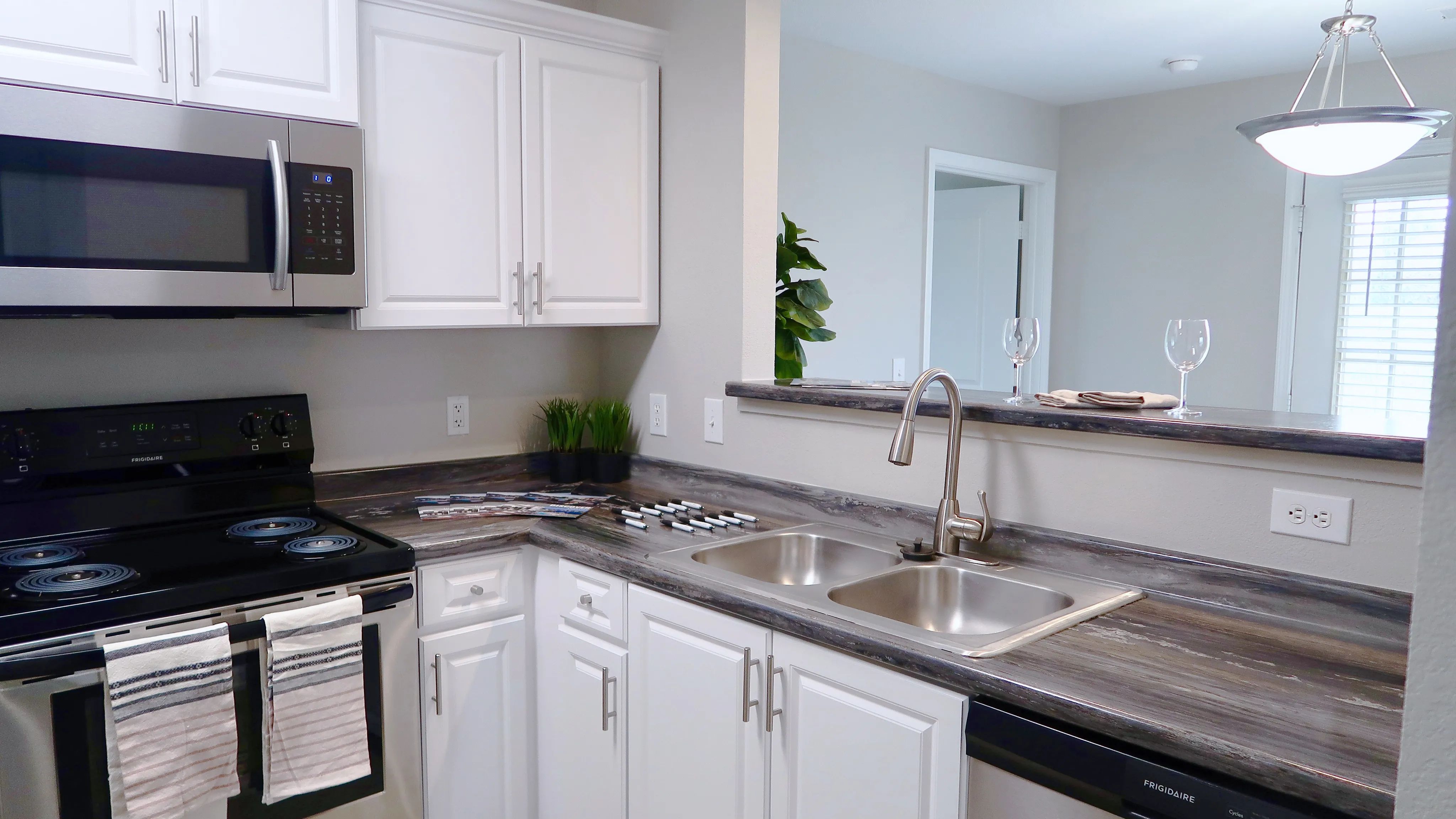 Revel in premier kitchens boasting black fusion granite-inspired countertops and modern white cabinetry for a chic culinary experience. 