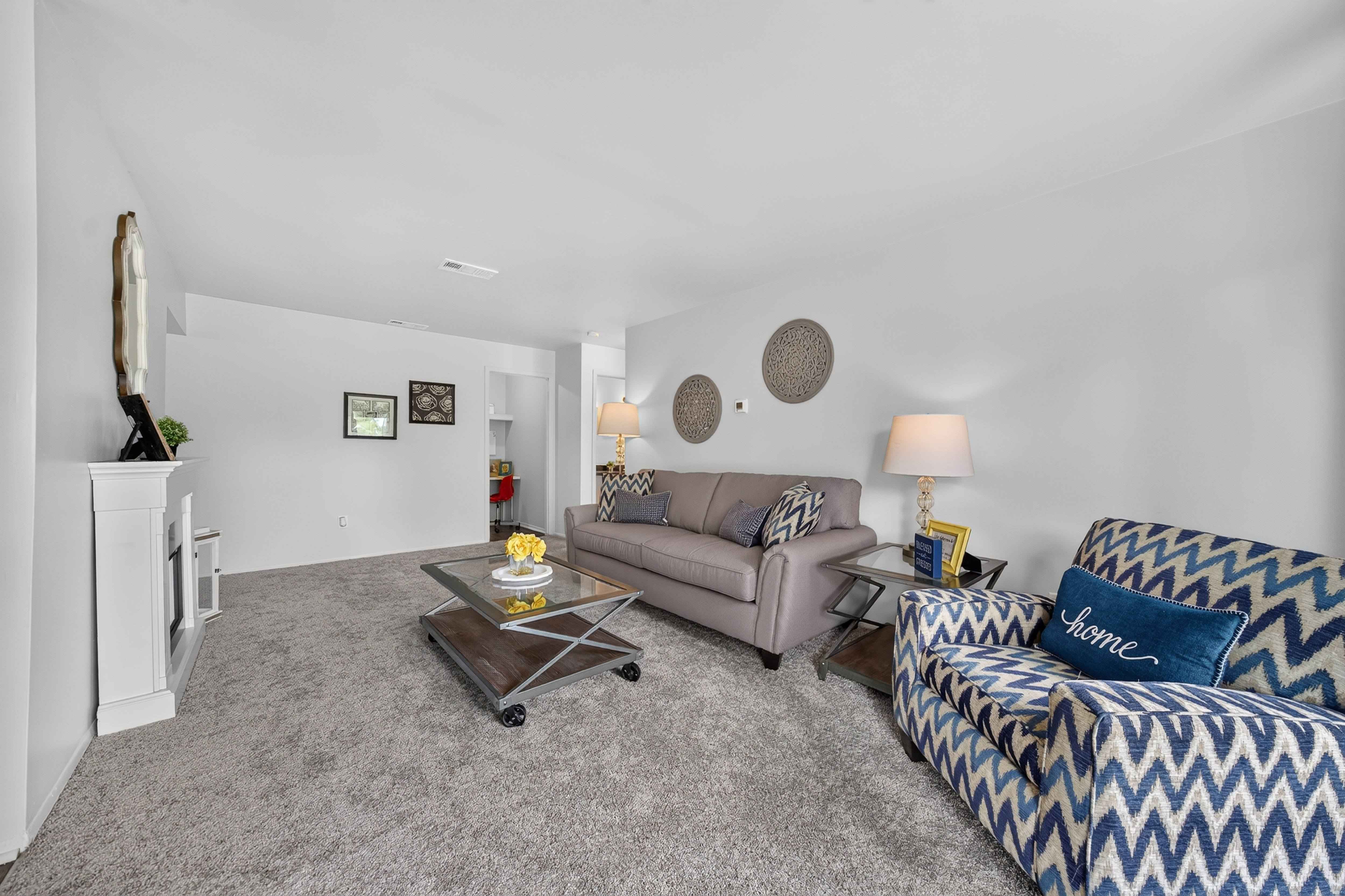 Elevated living room with a private balcony at Drawbridge Apartments in Harrison Township, MI.