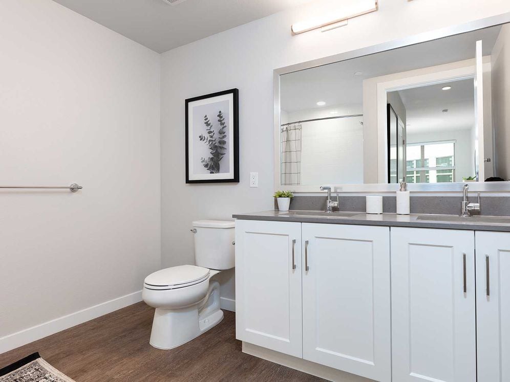 Upgrade Collection bath with white cabinetry, grey quartz countertop, and hard surface flooring