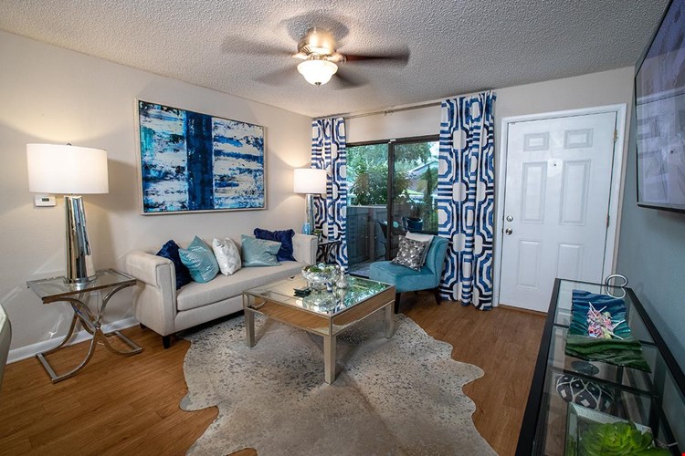 Spacious living room featuring wood-style flooring and a ceiling fan.