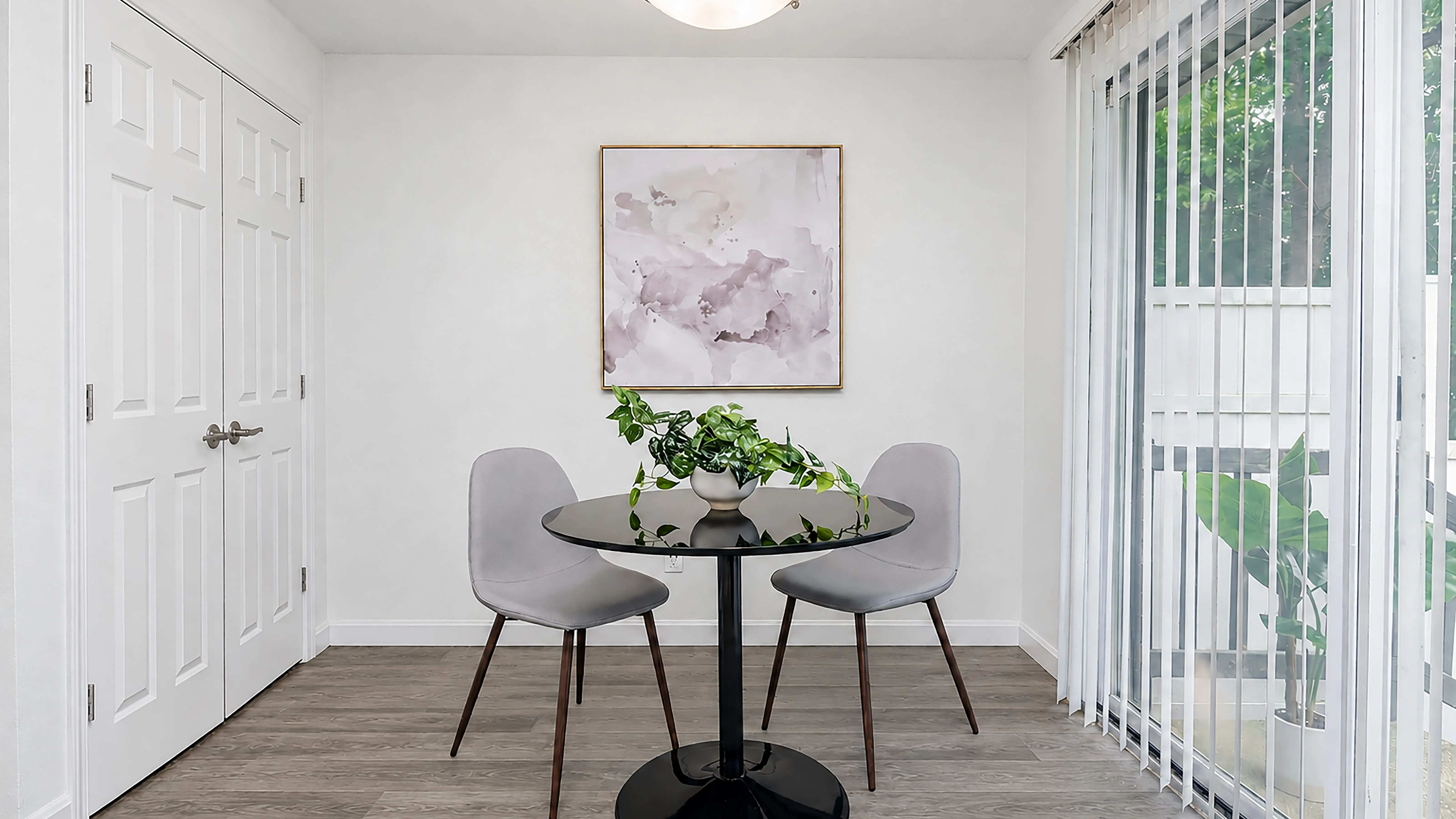 Enjoy a bright and inviting dining area featuring wood-style flooring and large sliding glass doors that fill the space with natural light and open to your private patio.