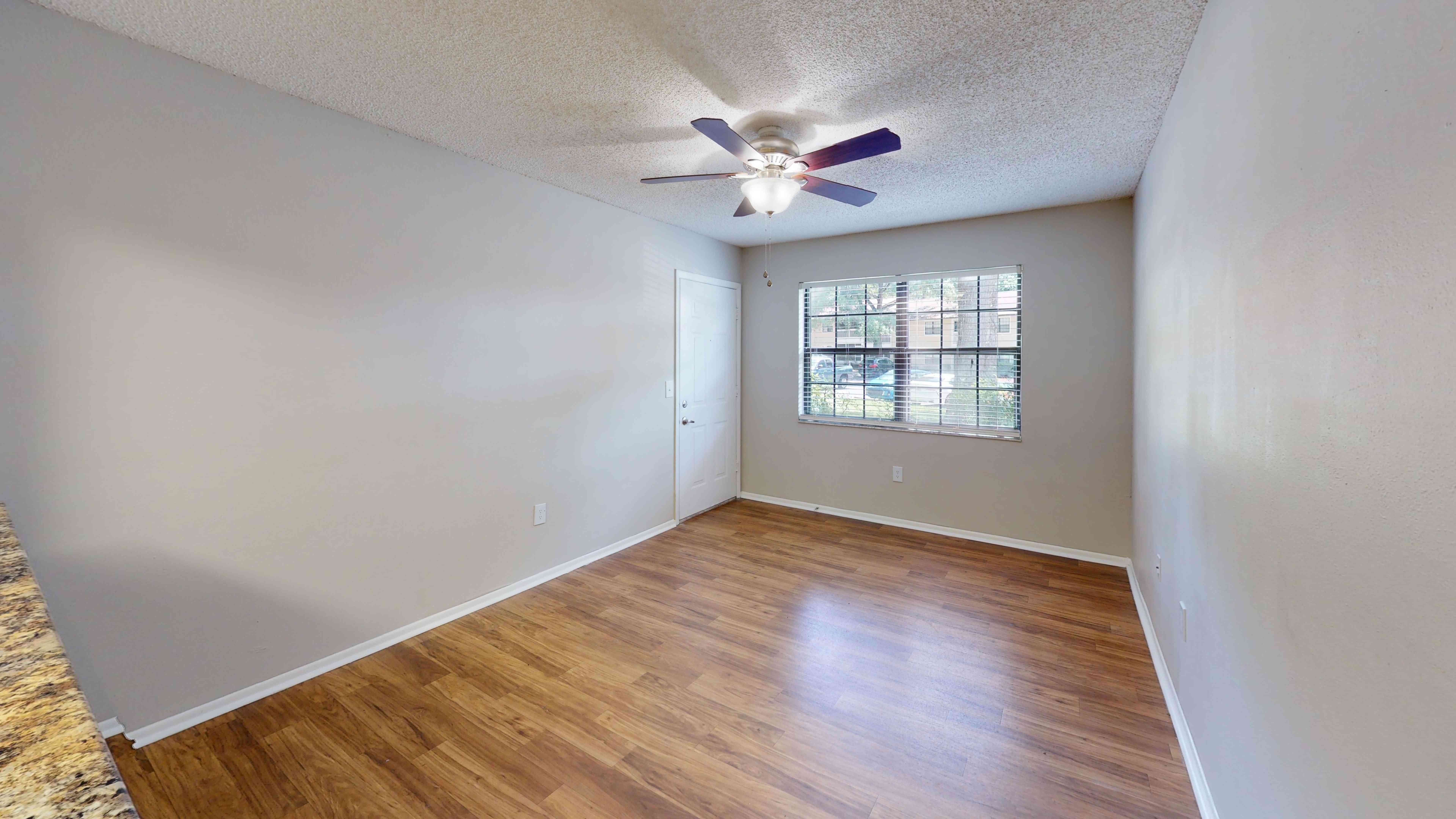 The Oakwood floor plan features a spacious living room features a spacious layout with wood-style flooring and a large window that fills the space with natural light.