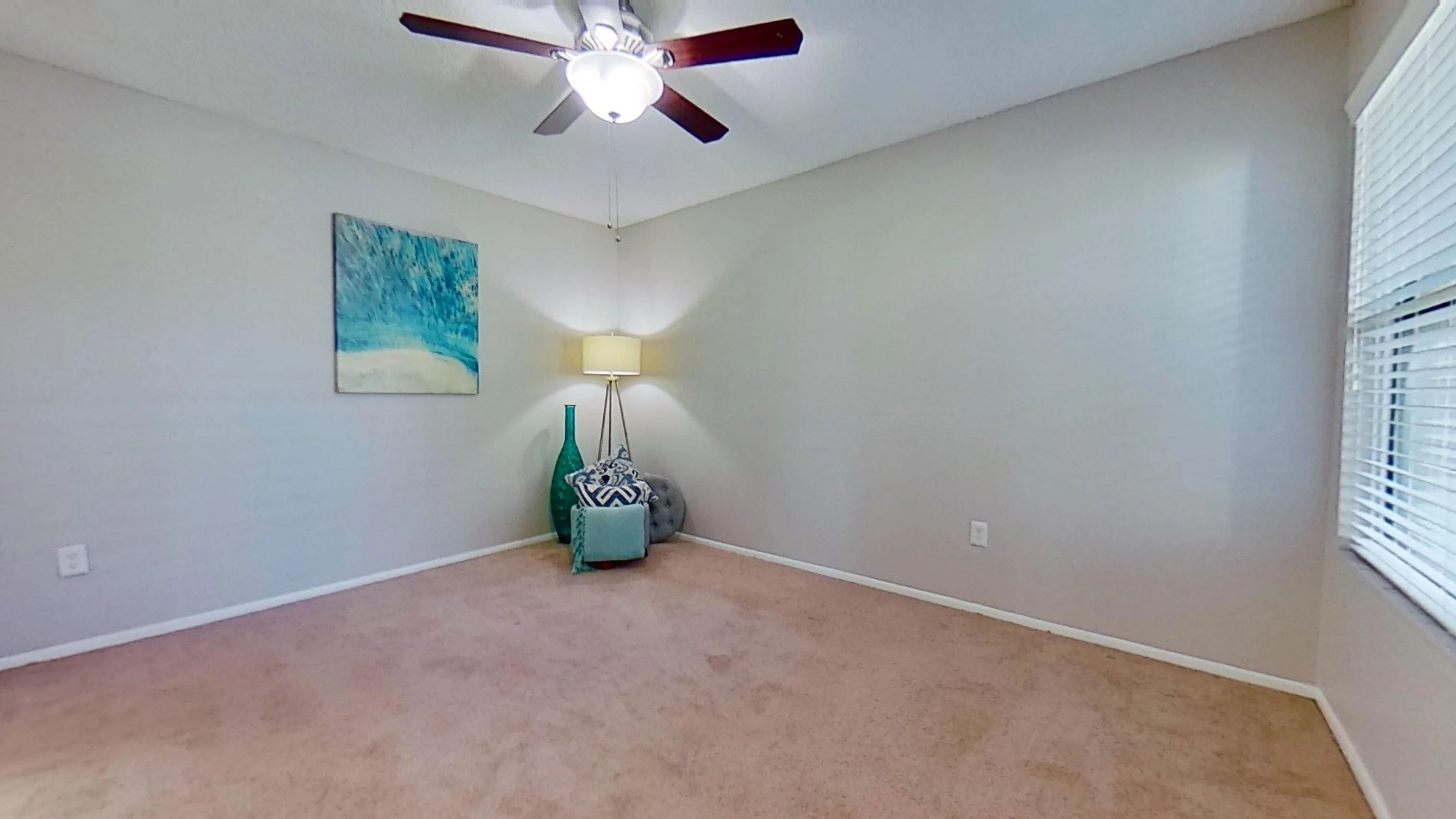 Discover the comfort of this bedroom in The Newport Autograph floor plan featuring cozy carpeting, ample natural light, and a ceiling fan for year-round comfort.
