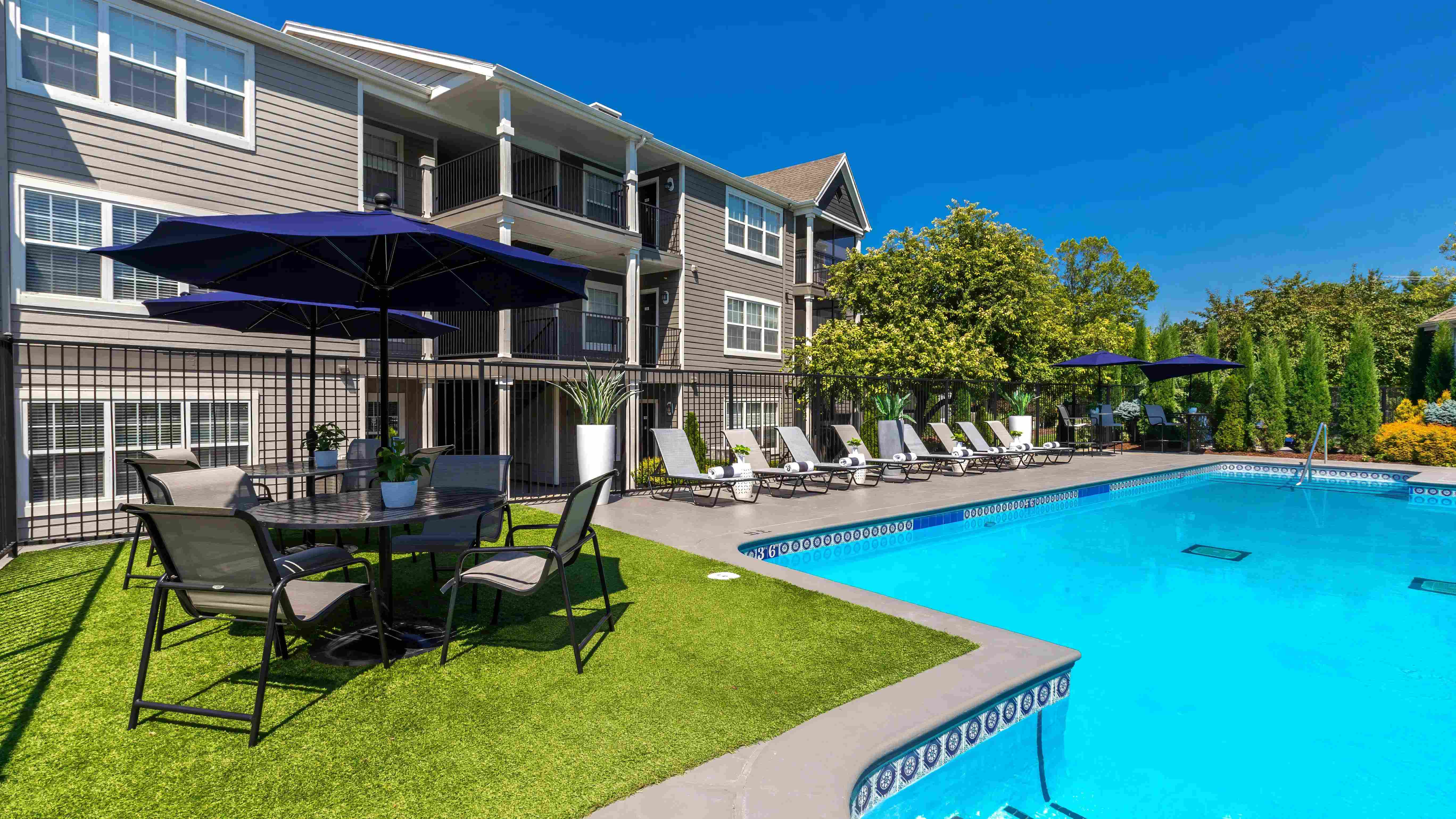 Savor shade and relaxation under stylish umbrellas at poolside tables.