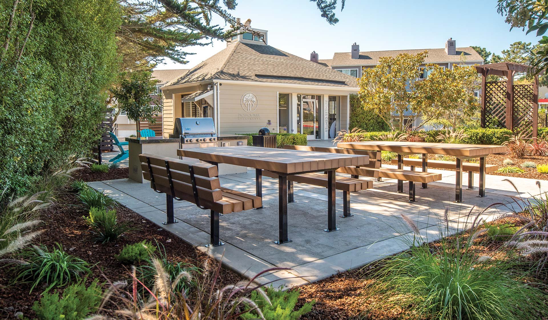 Host a barbecue at the outdoor lounge featuring a stainless steel gas grill and picnic tables