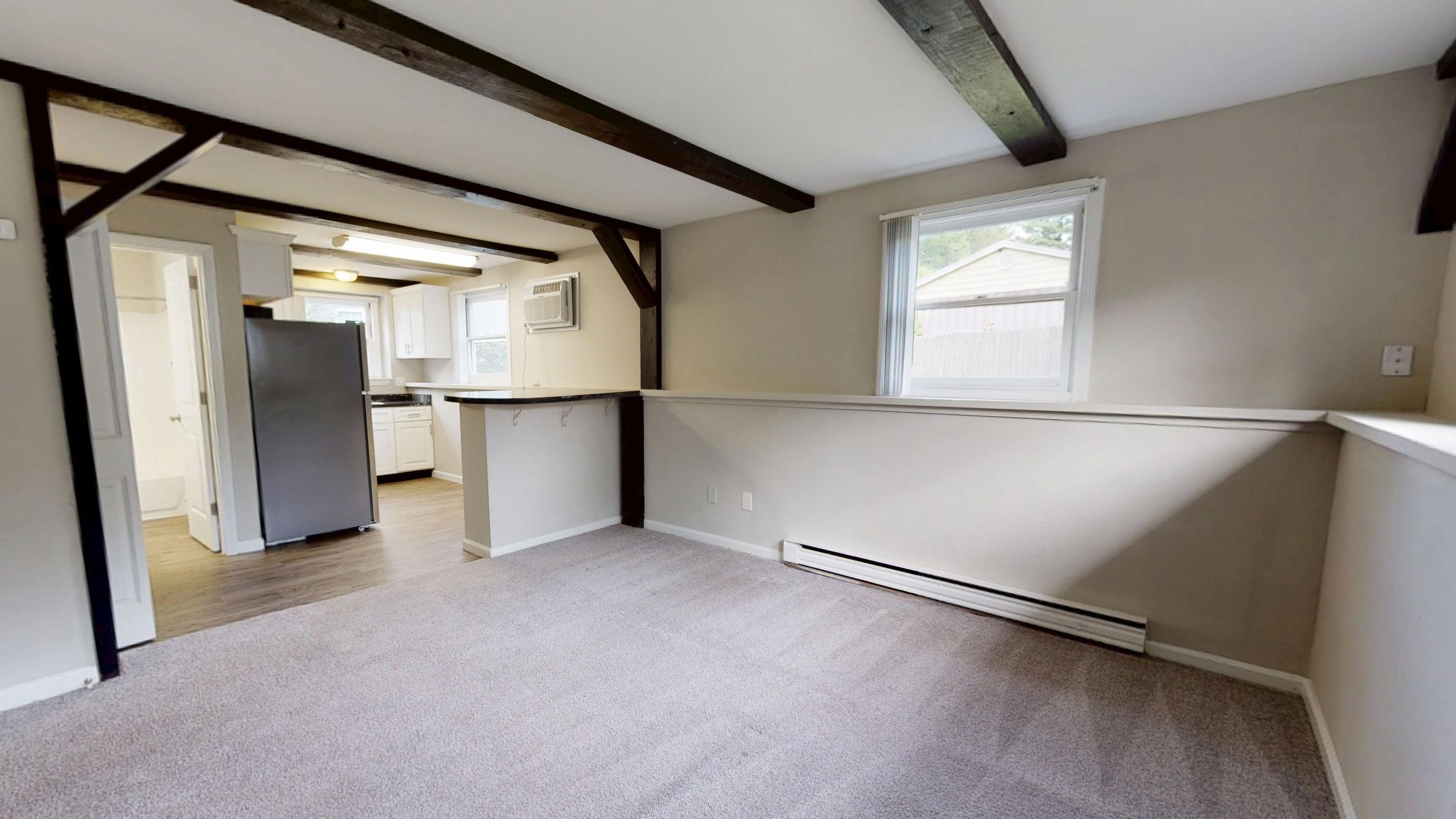 Experience the charm of our Hampshire studio with exposed beams, plush carpet, and an open-concept layout that flows into the kitchen.