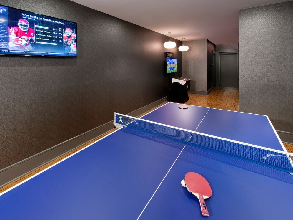 Resident lounge game room with ping pong table and flatscreen television