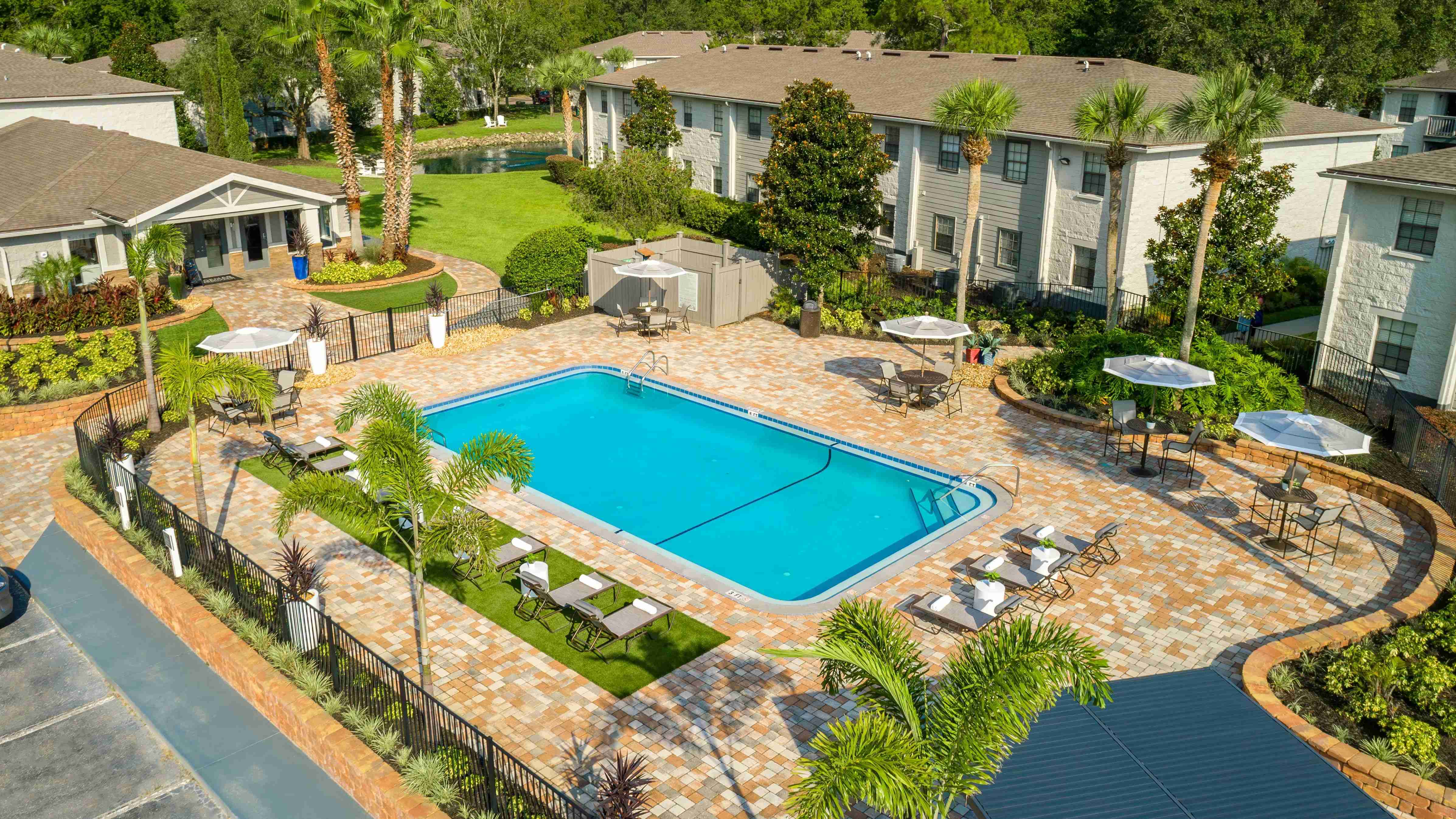 Lounge in luxury on our expansive sundeck, surrounded by lush palm trees and elegant poolside seating. 