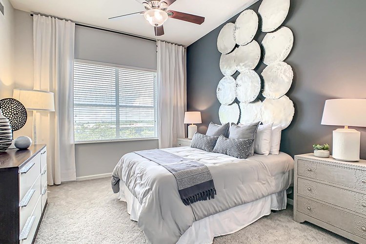 Spacious bedrooms with plush, neutral carpeting and ceiling fan.