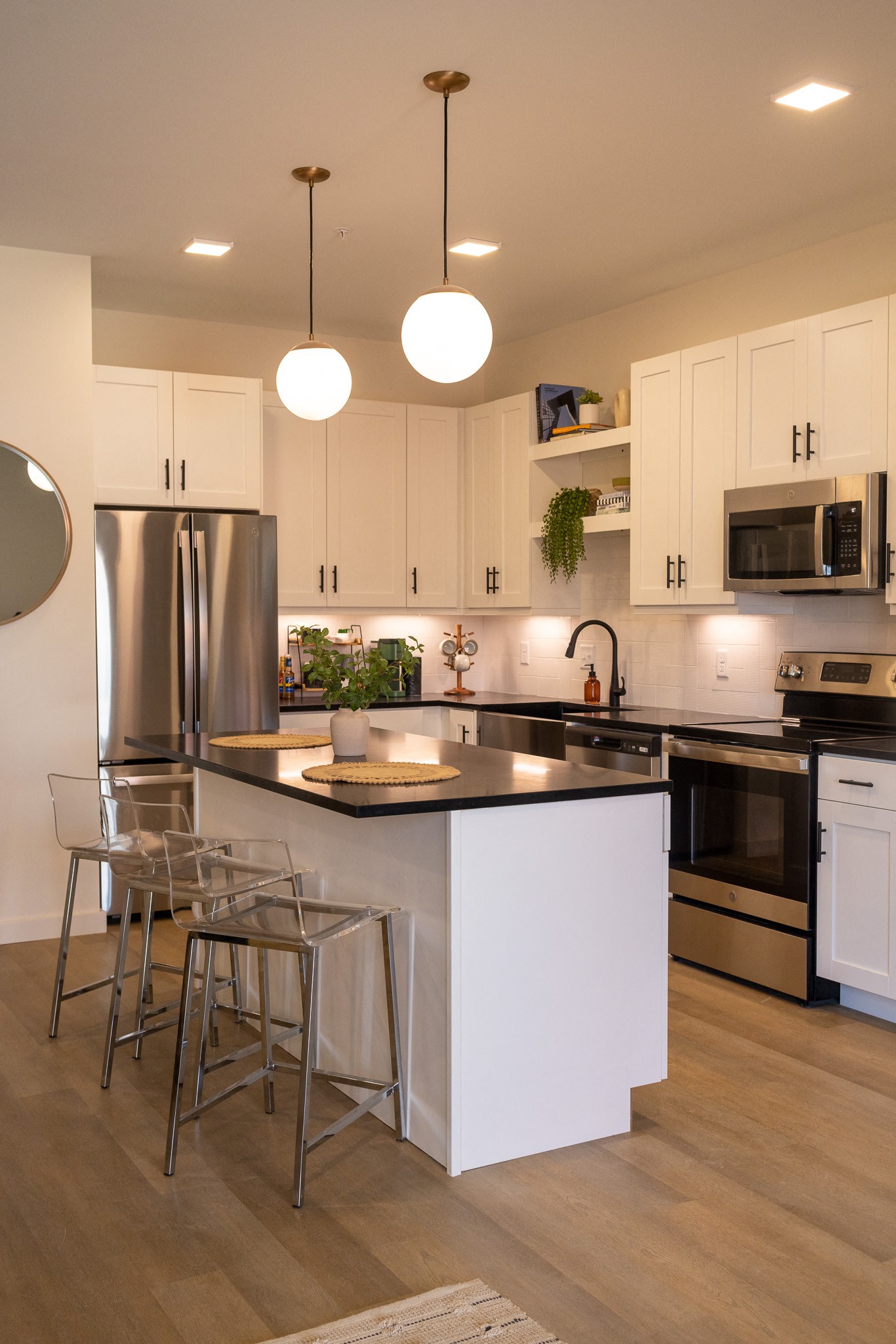 a kitchen with white cabinets and a large island with a black countertop