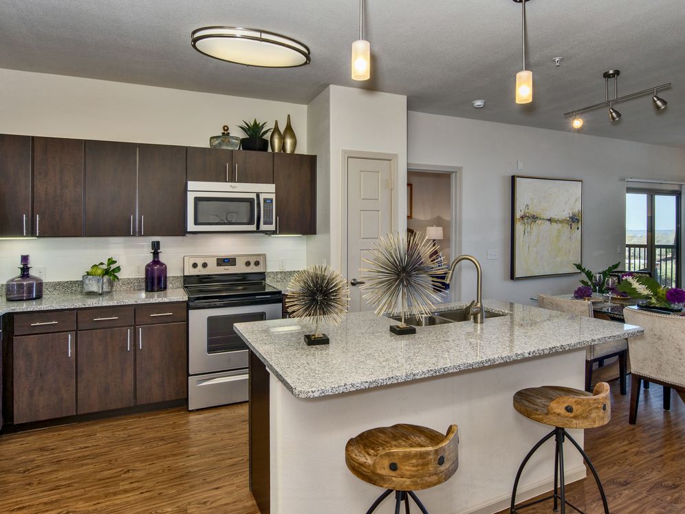 Classic Package I kitchen with espresso cabinetry, speckled granite countertops, white subway tile backsplash, stainless steel appliances, and hard surface flooring
