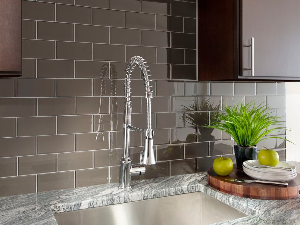 Kitchen with espresso cabinetry, granite countertop and tile backsplash