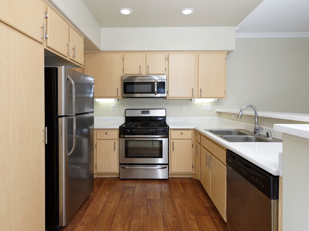 Kitchen with stainless steel appliances, laminate countertops, oak cabinetry, and hard surface flooring