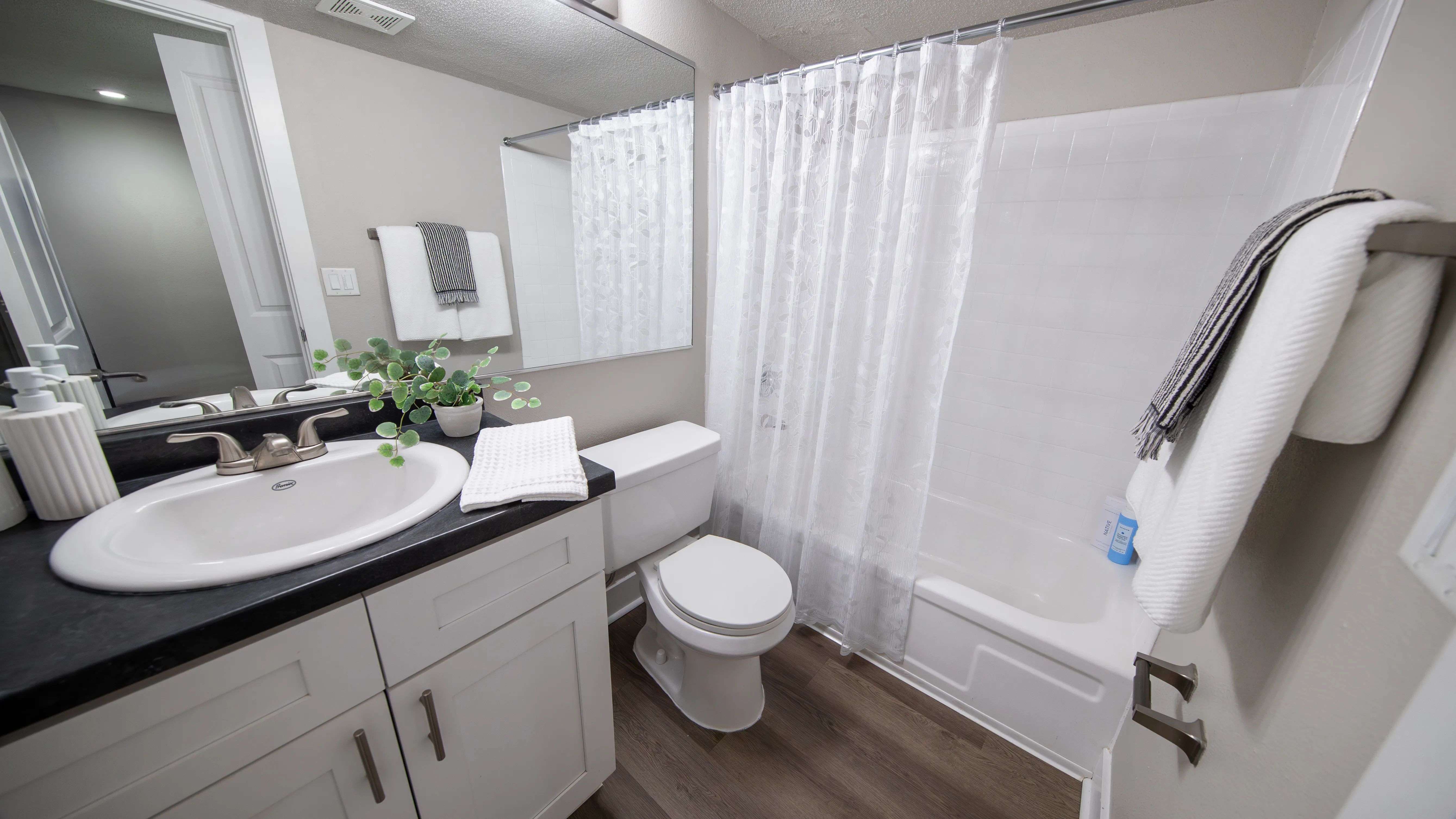 Enjoy the sleek and stylish design of our modern bathrooms featuring ample counter space, contemporary fixtures, wood-style flooring, and large mirrors.