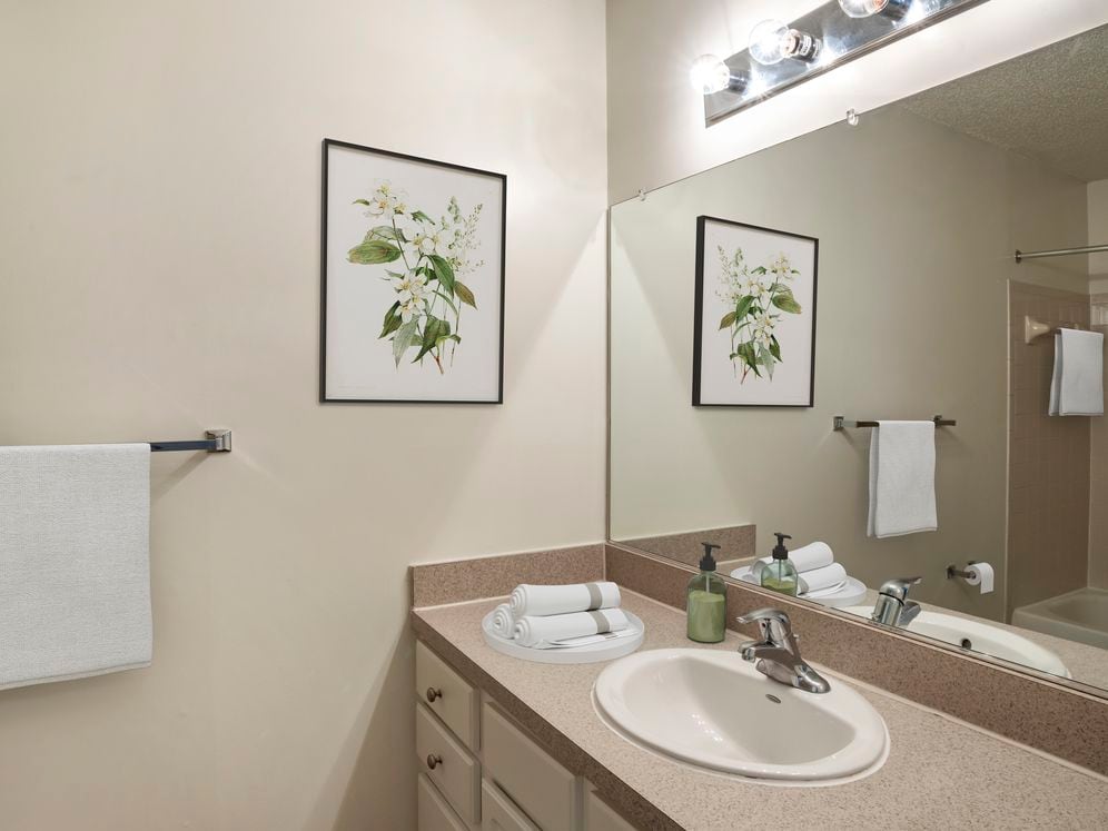Renovated Package I bath with laminate countertops, white cabinetry, and hard surface flooring