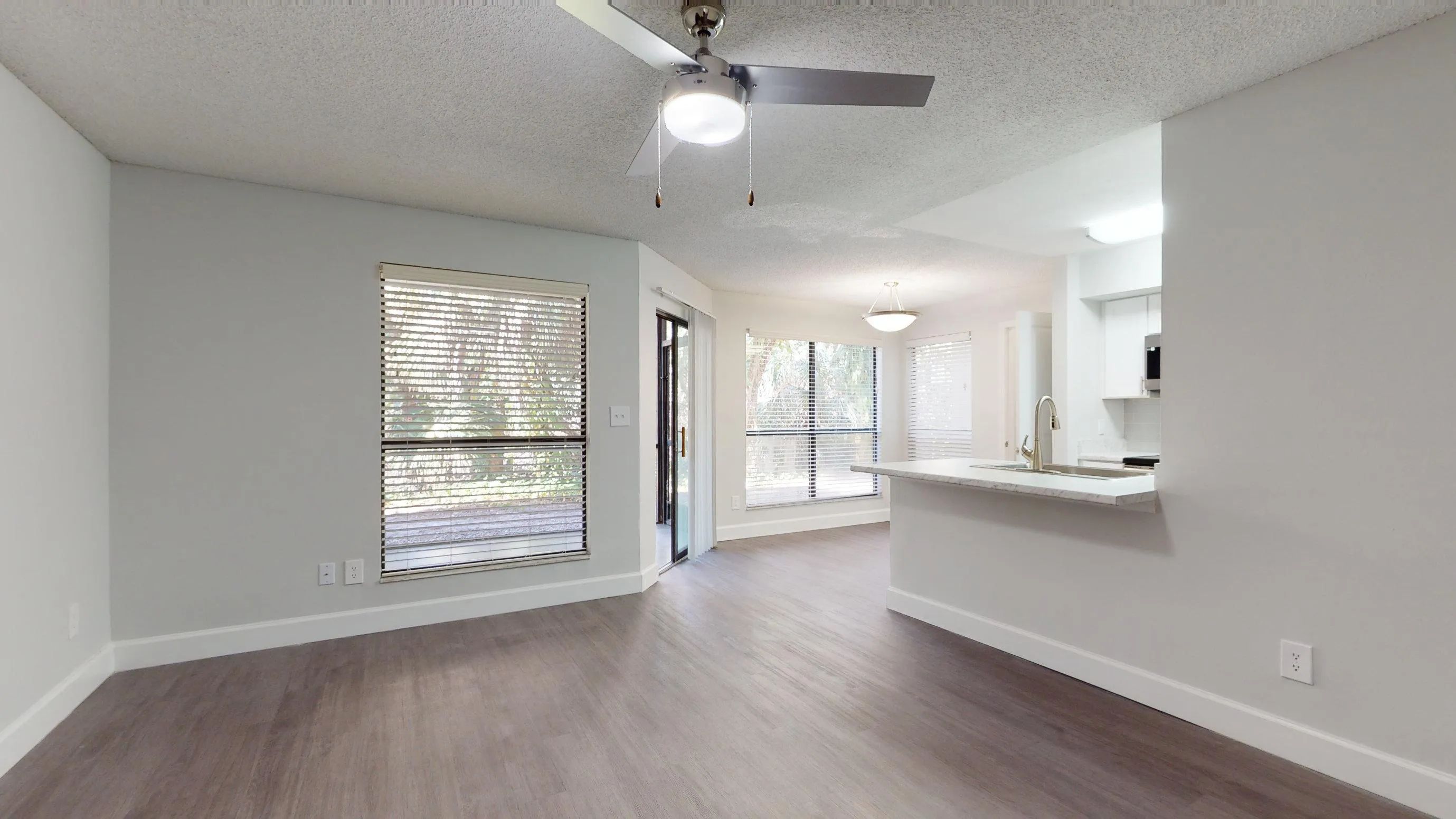 The Martinique floor plan offers a spacious open-concept living and dining area with large windows, modern lighting, and access to a private patio.