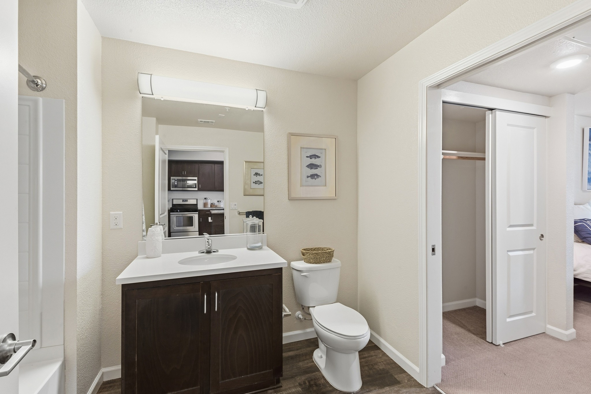 Aspire Apartments Tracy A bathroom with a toilet, sink, and mirror.