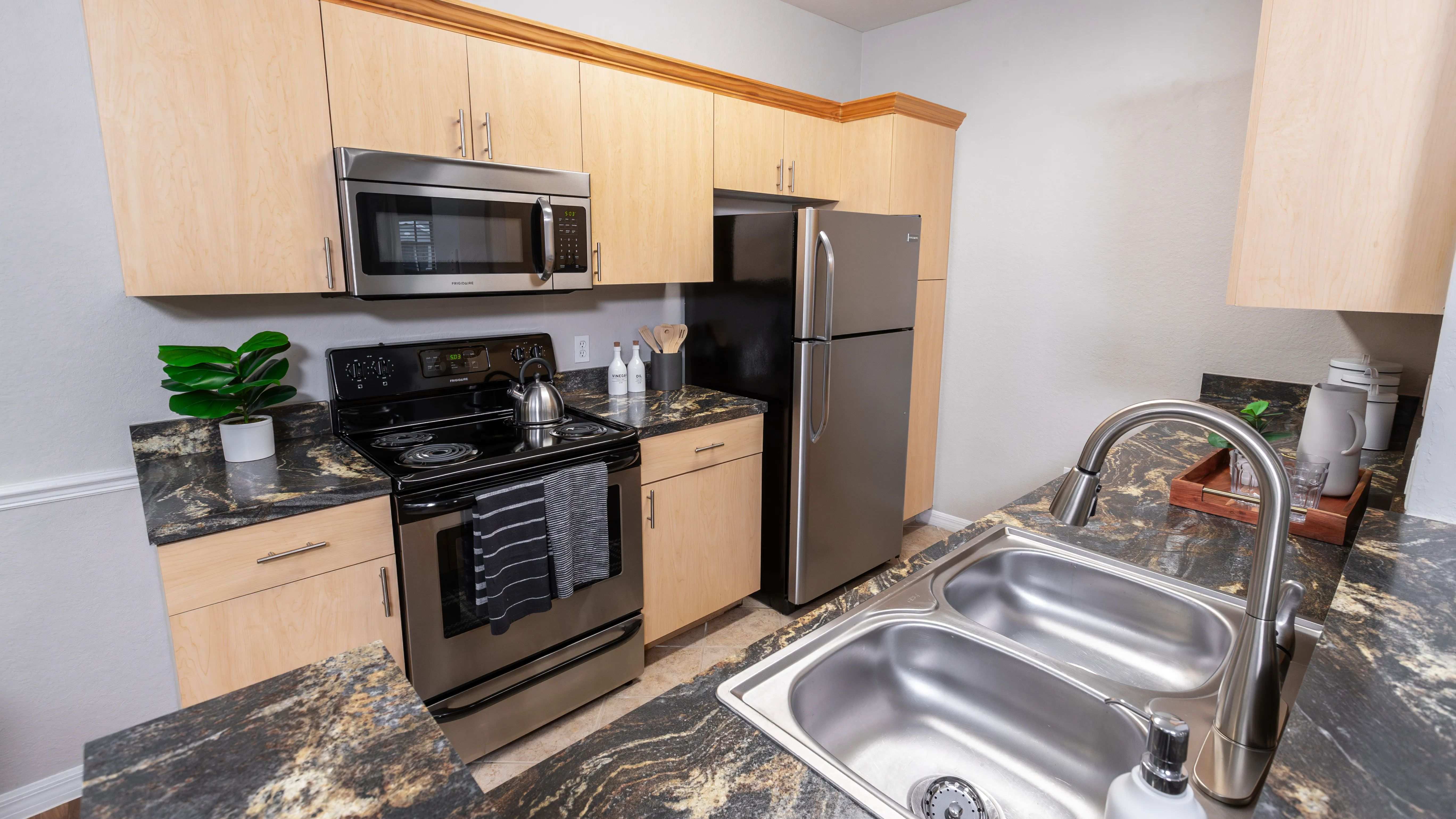 A beautifully designed kitchen with stainless steel appliances, ample cabinetry, and a dual sink setup.
