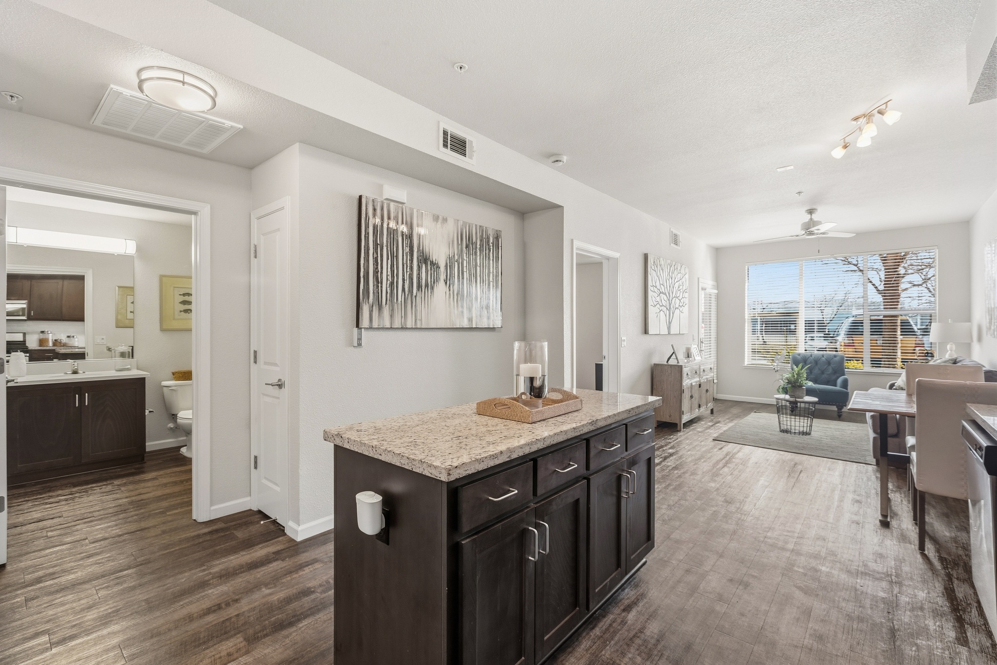 Aspire Apartments Tracy California A modern kitchen with dark wood cabinets and a granite countertop.