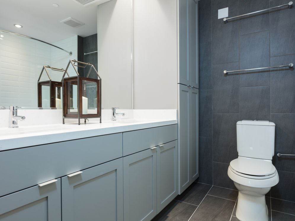 Signature Collection bathroom with double vanity, white countertop, grey cabinetry and tile flooring