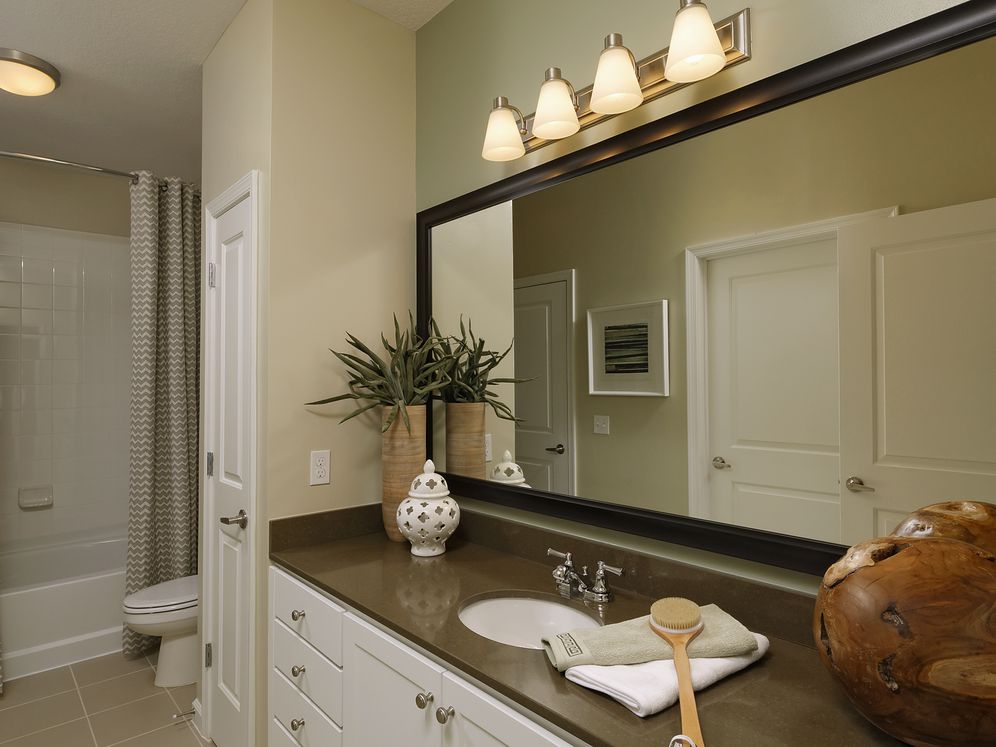 Bathroom with quartz stone countertop, white cabinetry and linen closet