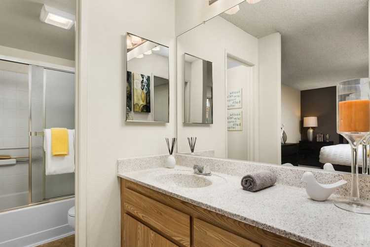 Classic Package bath with oak cabinetry, white speckled granite countertop, and tile flooring