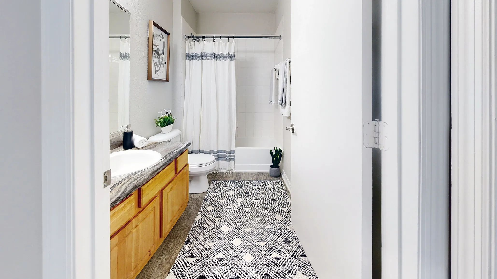 Serenity resides in the details of our signature bathroom at Eagle's Pointe. Immerse yourself in comfort and style with updated, refined finishes including wood-style flooring and black fusion countertops. 