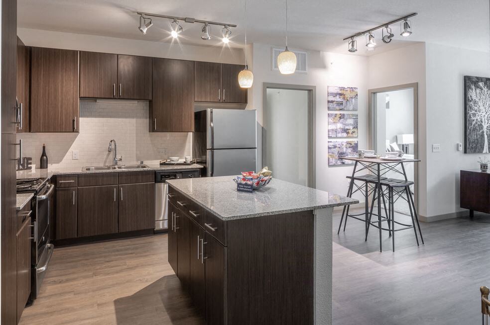 Centro Apartments model kitchen with brown cabinets and island