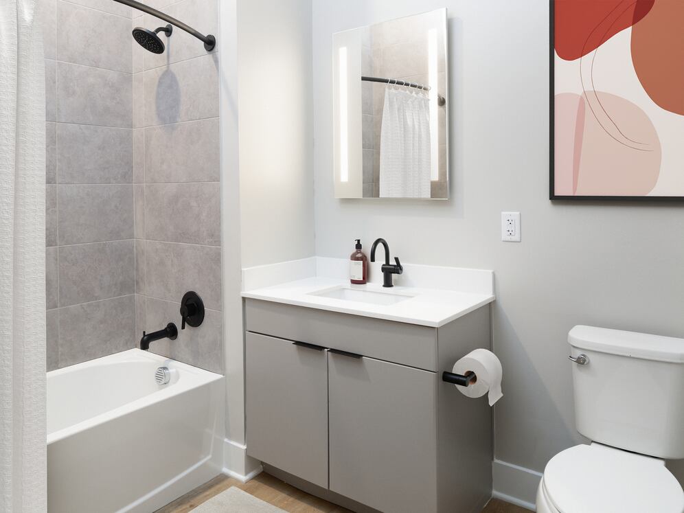 Signature Collection bath with LED vanity mirror, white quartz countertop, light grey cabinetry, and hard-surface flooring