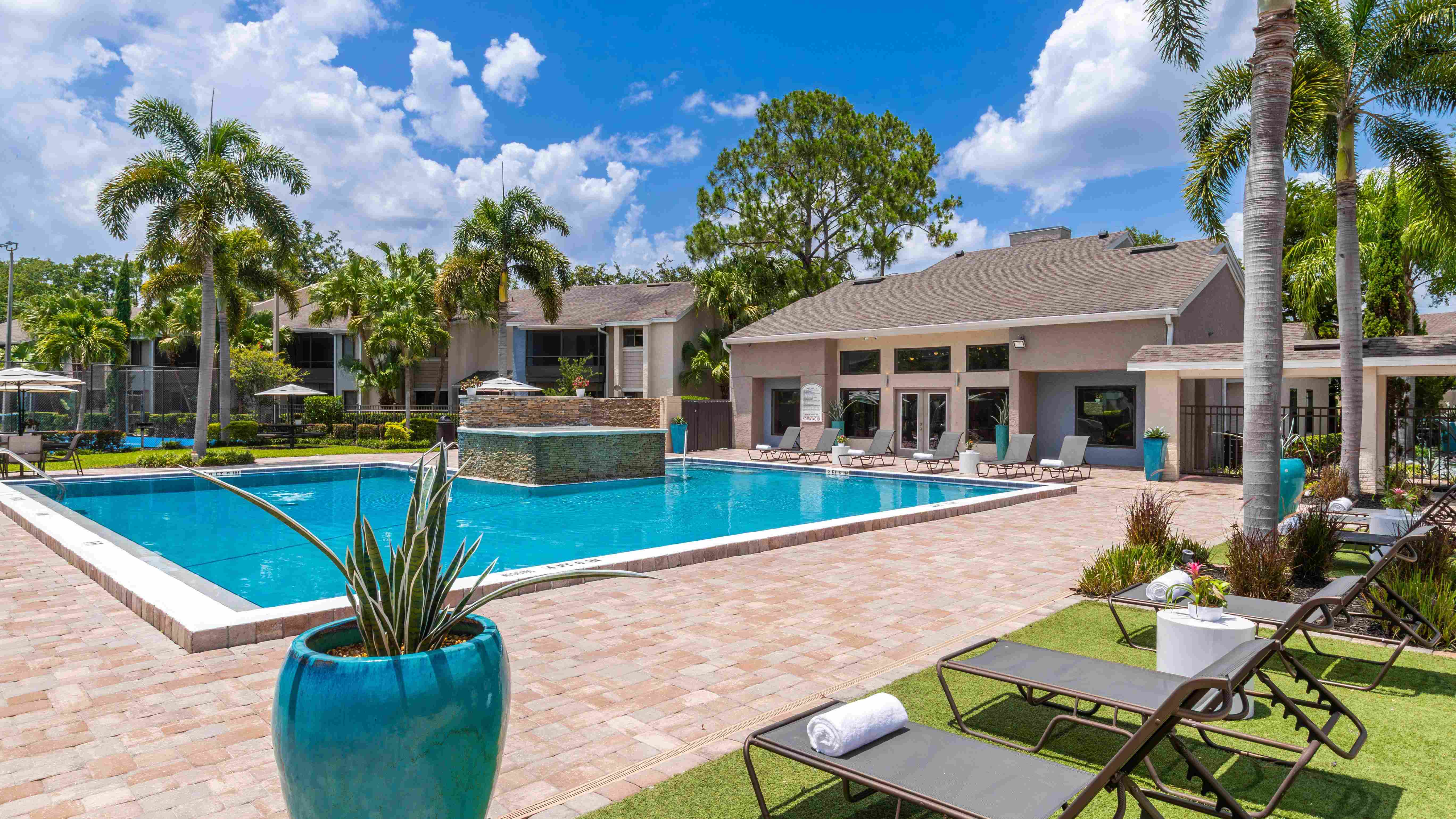 Dive into comfort at Harper Grand’s expansive pool area—perfect complete with lounge chairs, lush landscaping, and a tranquil water feature.